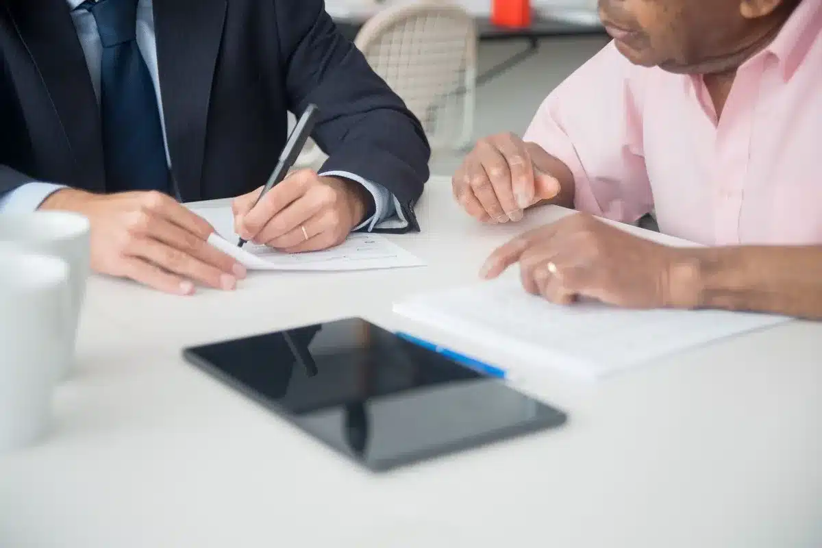 Zelfstandige en opdrachtgever bespreken en ondertekenen een contract met verzekeringseisen