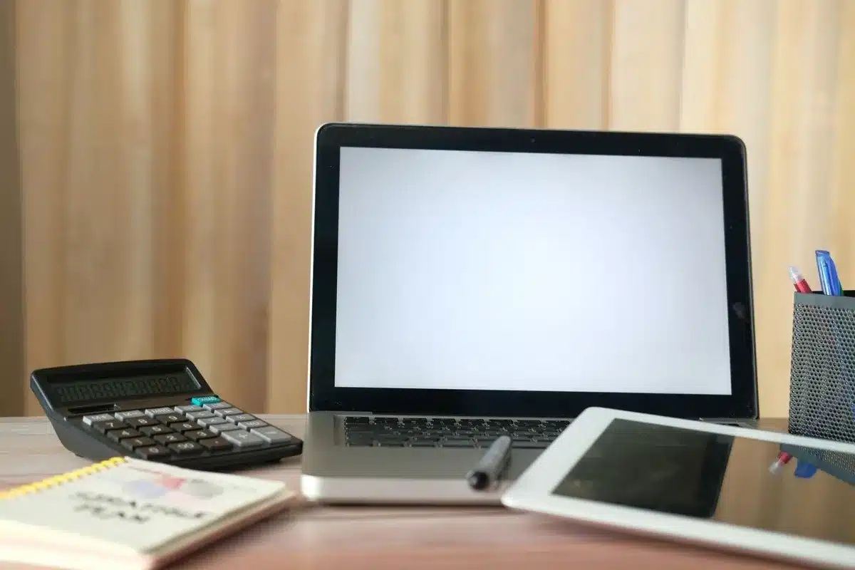 Opgeruimd bureau met laptop, tablet en rekenmachine klaar voor de zzp administratie