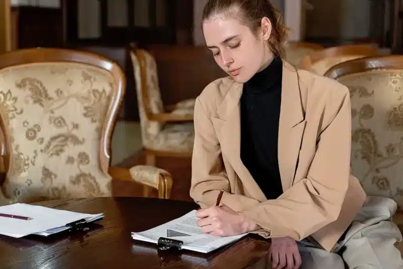 Ondernemer ondertekent documenten aan tafel bij de keuze tussen eenmanszaak of bv