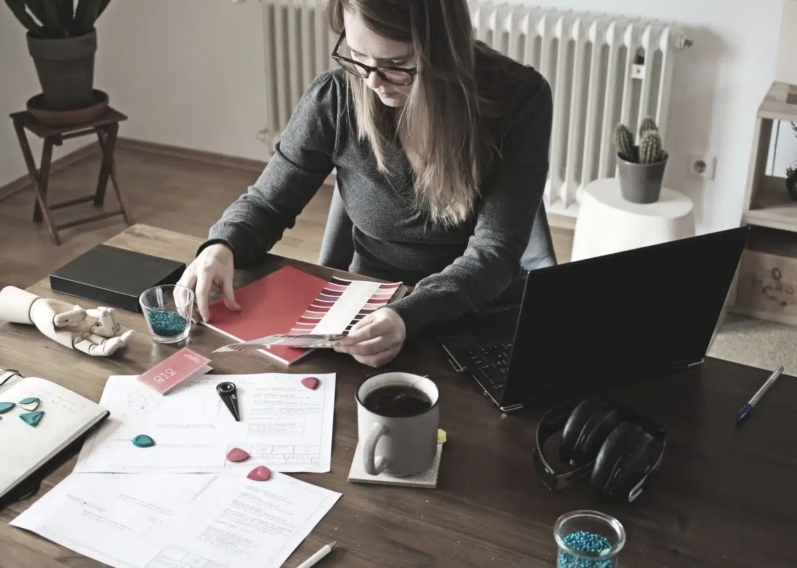 Freelancer aan het werk aan een bureau met laptop en papieren in haar thuiskantoor