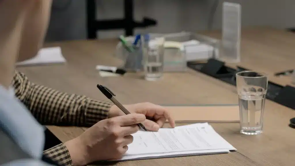 Zzp'er ondertekent een offerte aan houten tafel in kantoor na akkoord met klant