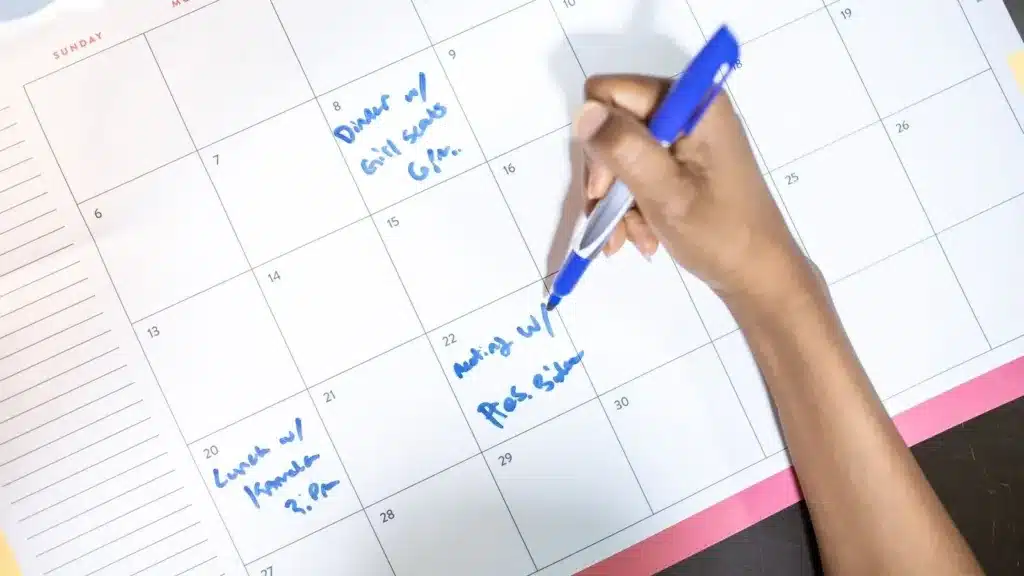 Zzp'er noteert gewerkte uren en afspraken in een bureaukalender voor het urencriterium