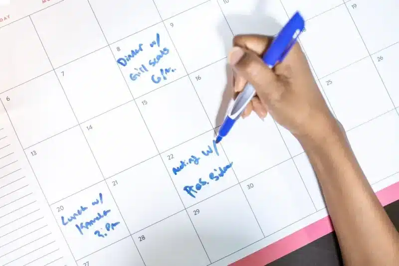 Zzp'er noteert gewerkte uren en afspraken in een bureaukalender voor het urencriterium