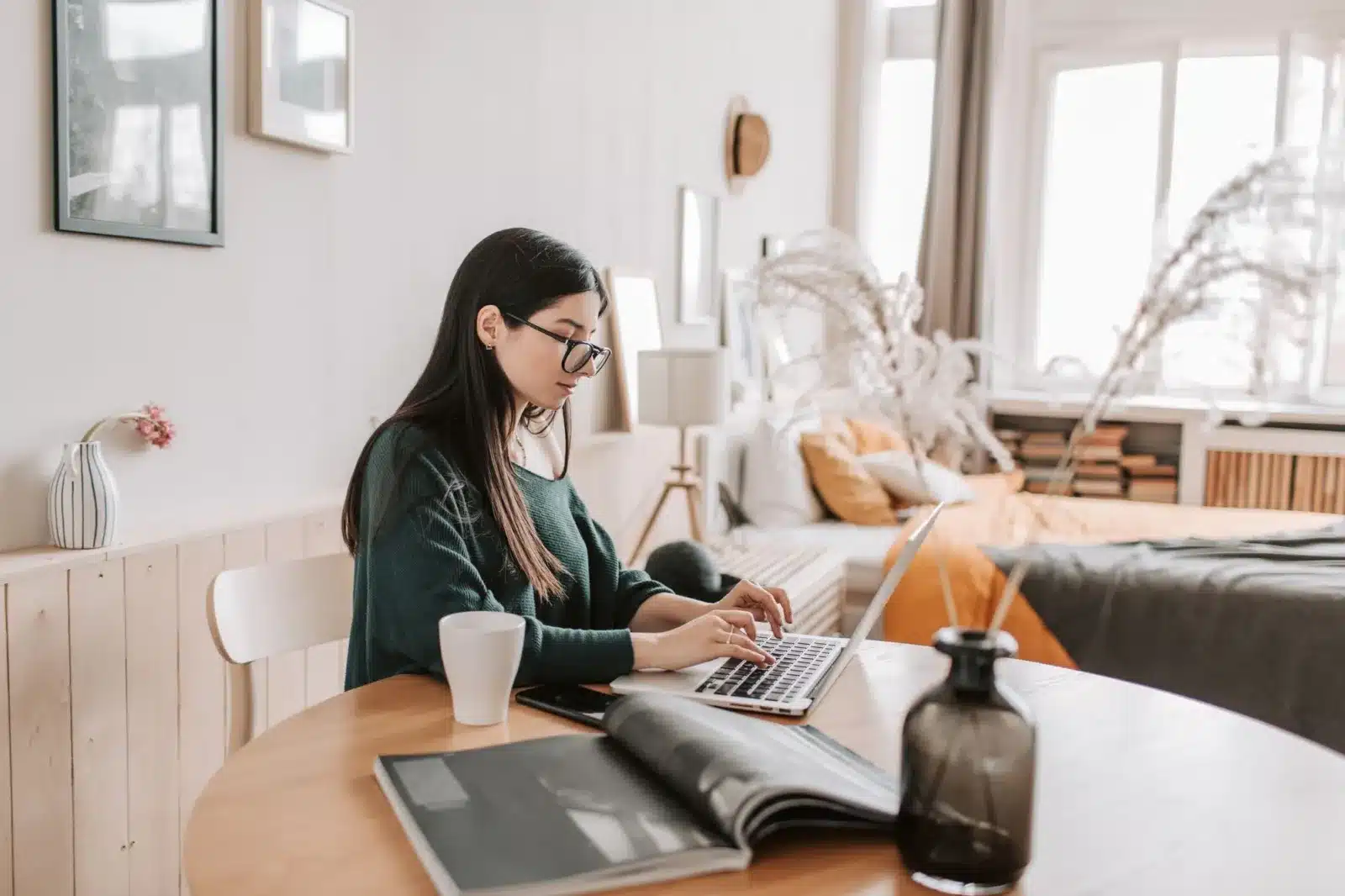 Zzp'er werkt thuis aan een ronde tafel met laptop en notitieboek